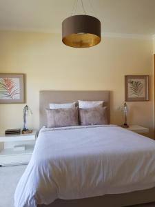 una camera da letto con un grande letto bianco con cuscini di JARDINS DA MARINA APARTMENT Ai ad Albufeira