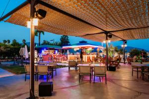 a restaurant with tables and chairs under umbrellas at night at Hotel Caprea in Marmaris