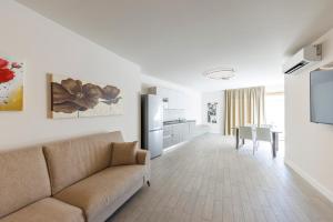 a living room with a couch and a kitchen at Exclusive Suites Riva in Riva del Garda