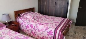 a bedroom with a bed with a pink comforter at Apto Duplex Familias Numerosas Centro Pasto in Pasto