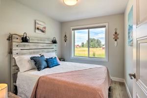 a bedroom with a bed with blue pillows and a window at Red Lodge Home with Patio about 1 Mi from Downtown! in Red Lodge