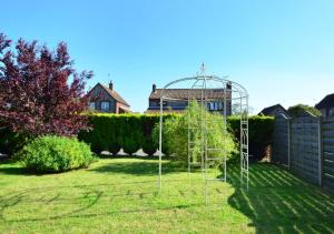 a garden with a climbing frame in the grass at Avocet House in Langham