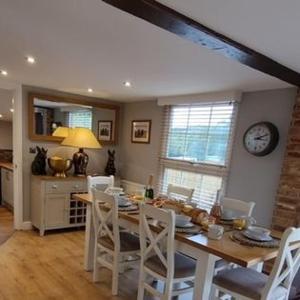 a kitchen and dining room with a table and chairs at Harewell wood cabin in Pateley Bridge