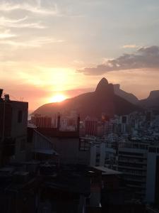 una puesta de sol sobre una ciudad con una montaña en el fondo en Hostel Yes Brasil, en Río de Janeiro
