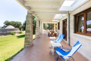 2 blaue Stühle und ein Tisch auf der Veranda in der Unterkunft Villa Alerika in Carovigno