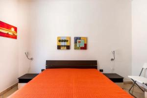 ein Schlafzimmer mit einem Bett mit einer orangefarbenen Decke in der Unterkunft Villa Alerika in Carovigno