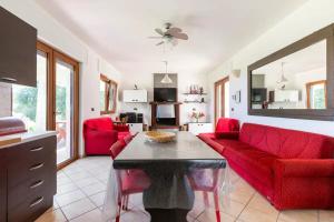 ein Wohnzimmer mit roten Möbeln und einem roten Sofa in der Unterkunft Villa Alerika in Carovigno