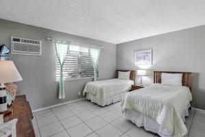 a bedroom with two beds and a window at Idyllic condo with brief walk to beach and restaurants in Marco Island +28 photos