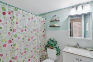 a bathroom with a shower curtain with a toilet and a sink at Idyllic condo with brief walk to beach and restaurants in Marco Island +29 photos