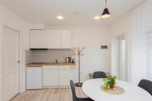 a kitchen and dining room with a table and chairs at Mėlyna banga in Palanga
