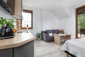 a kitchen and a living room with a couch at Na mieczowej 2f in Świnoujście +15 photos