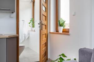 a bathroom with a toilet and a door with a window at Na mieczowej 2f in Świnoujście