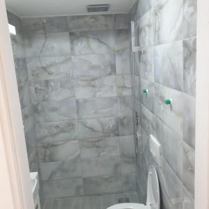 a bathroom with a toilet and a marble wall at Gas Otel in Belgrade