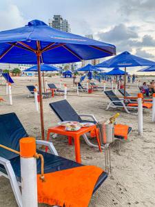 a group of chairs and umbrellas on a beach at Hotel Cabreromar in Cartagena de Indias
