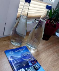 twee flessen water en een boek op een tafel bij Apartament Marasesti in Piteşti