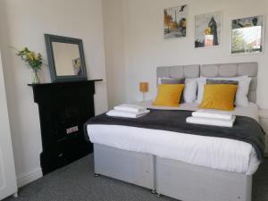 a bedroom with a large bed with yellow pillows at Ermine Rd Hoole - Period Victorian House by Rework Accommodation in Chester