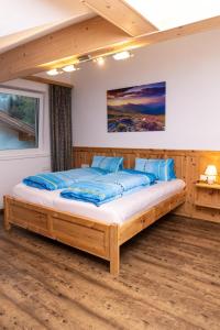 a bedroom with a large wooden bed with blue pillows at Ferienwohnungen Hinterstein in Hart im Zillertal