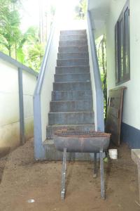 a staircase with a rusty pot in front of a building at Forestay -3 BHK Villa Kochi in Pallipuram