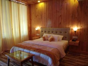 a bedroom with a large bed and a table at white coral beach resort in Havelock Island