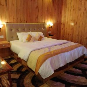 una camera da letto con un grande letto e pareti in legno di white coral beach resort a Isola di Havelock