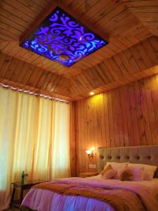 um quarto com uma cama com uma luz azul no tecto em white coral beach resort em Ilha Havelock