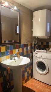 y baño con lavabo y lavadora. en Casa Zapatero en Somontano, en Salas Bajas