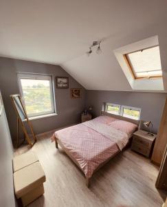 een slaapkamer met een bed en 2 ramen bij "U Mamy Róży" - Pokoje Gościnne in Reda