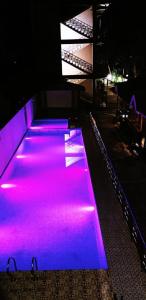 uma pista de bowling iluminada de púrpura à noite em white coral beach resort em Ilha Havelock