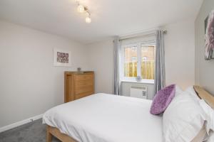 1 dormitorio con cama blanca y ventana en The Nelson - Spacious City Property and Free Parking, en Glasgow