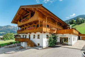 a large wooden building with a balcony at Aparthotel Hummerau in Alpbach