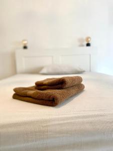 dos toallas sentadas encima de una cama en M's Residences Maiolica, en Trieste
