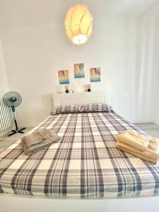 a bedroom with a bed with a plaid blanket at M's Residences Maiolica in Trieste