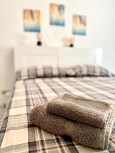 una pila de toallas sentadas encima de una cama en M's Residences Maiolica, en Trieste