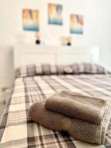 a pile of towels sitting on top of a bed at M's Residences Maiolica in Trieste