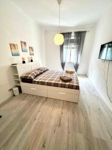 a bedroom with a large bed in a white room at M's Residences Maiolica in Trieste