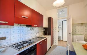 cocina con armarios rojos y fogones en 1 Bedroom Stunning Apartment In Genova, en Génova