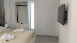 1 dormitorio con 2 toallas en una cama y TV en 3B Aurora - Bed Breakfast and Boat, en Salerno