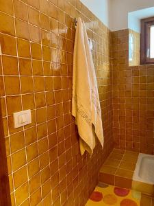 a tiled bathroom with a towel hanging on a wall at B&B Santa Caterina in Acquaviva Picena