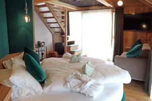 Un dormitorio con una cama grande con almohadas verdes y blancas en Alpine Residence Villa Adler, en San Vigilio Di Marebbe