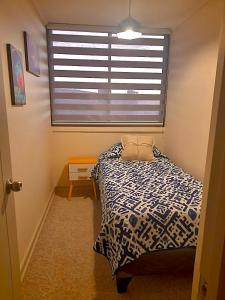 Departamento VIP vista al Mar y Ciudad في فالبارايسو: غرفة نوم صغيرة بها سرير ونافذة