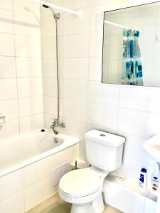Departamento VIP vista al Mar y Ciudad في فالبارايسو: حمام ابيض مع مرحاض وحوض استحمام