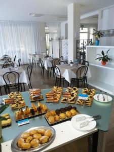 a table with many different types of pastries on it at B&B - Meuble' - Hotel " CORDIALE " in Misano Adriatico