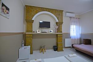 a living room with a couch and a tv at R.Gold Apartman in Makó