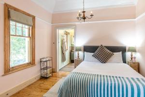 a bedroom with a large bed and a window at Villa Bianca B & B in Cape Town