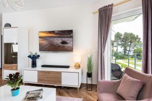 a living room with a couch and a table at Apartament w Gąskach - Anielskie Wakacje in Gąski