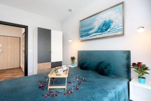 um quarto com uma cama azul com flores no chão em Apartament w Gąskach - Anielskie Wakacje em Gąski