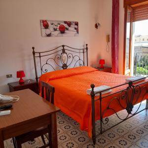 ミラッツォにあるHotel Californiaのベッドルーム1室(オレンジ色のベッドカバー付)