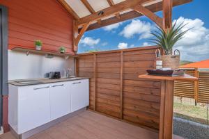 une cuisine extérieure avec une clôture en bois et une table dans l'établissement Bungalow Pom 1, piscine, à 5 min des plages, au Vauclin