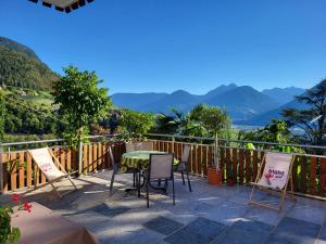 a patio with a table and chairs and mountains at Panorama Residence Rebgut in Schenna