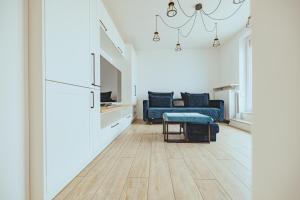 een woonkamer met een blauwe bank en een tafel bij Apartament Szlachecka in Warschau